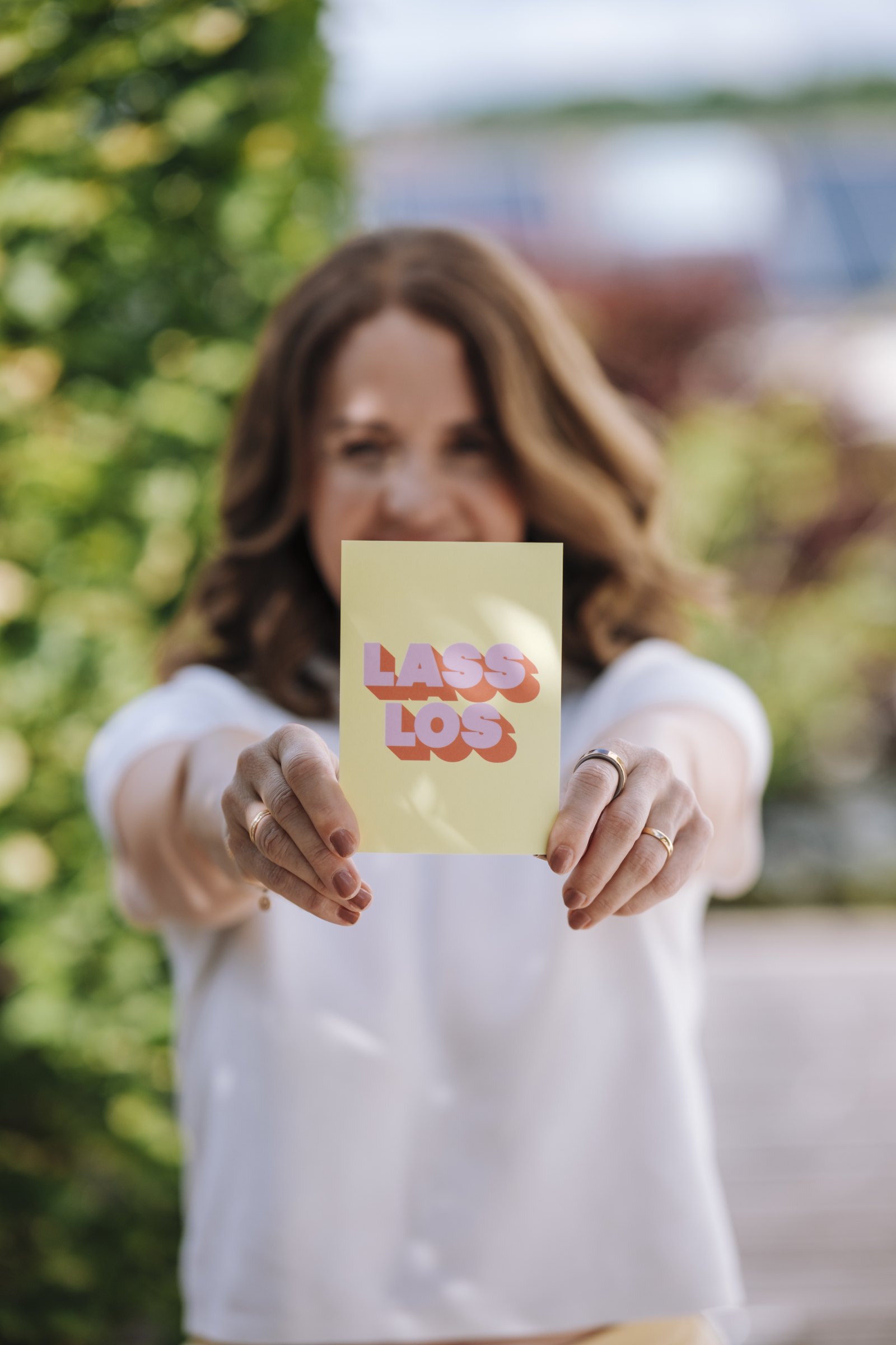 Claudia Lässig hält eine Karte mit der Aufschrift ‚Lass los‘ in die Kamera.